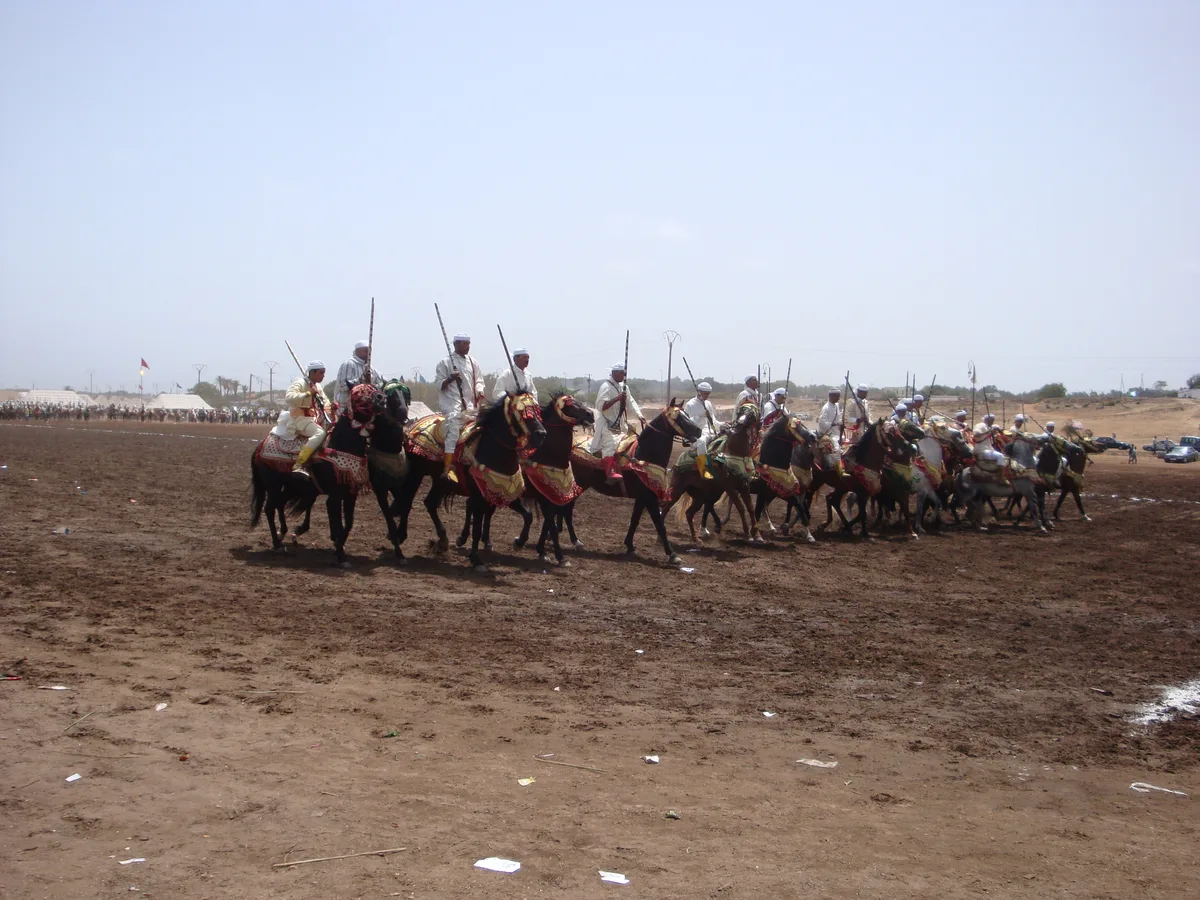 A line of Fantasia horsemen in white robes preparing to charge